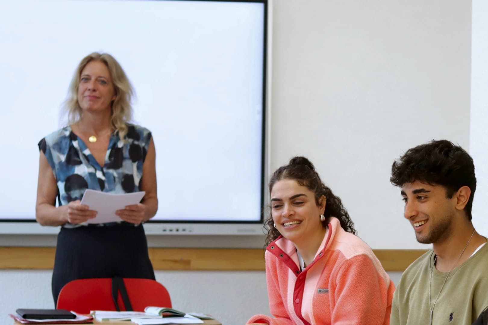 Eine Lehrerin und lächelnde Teilnehmende im Unterricht