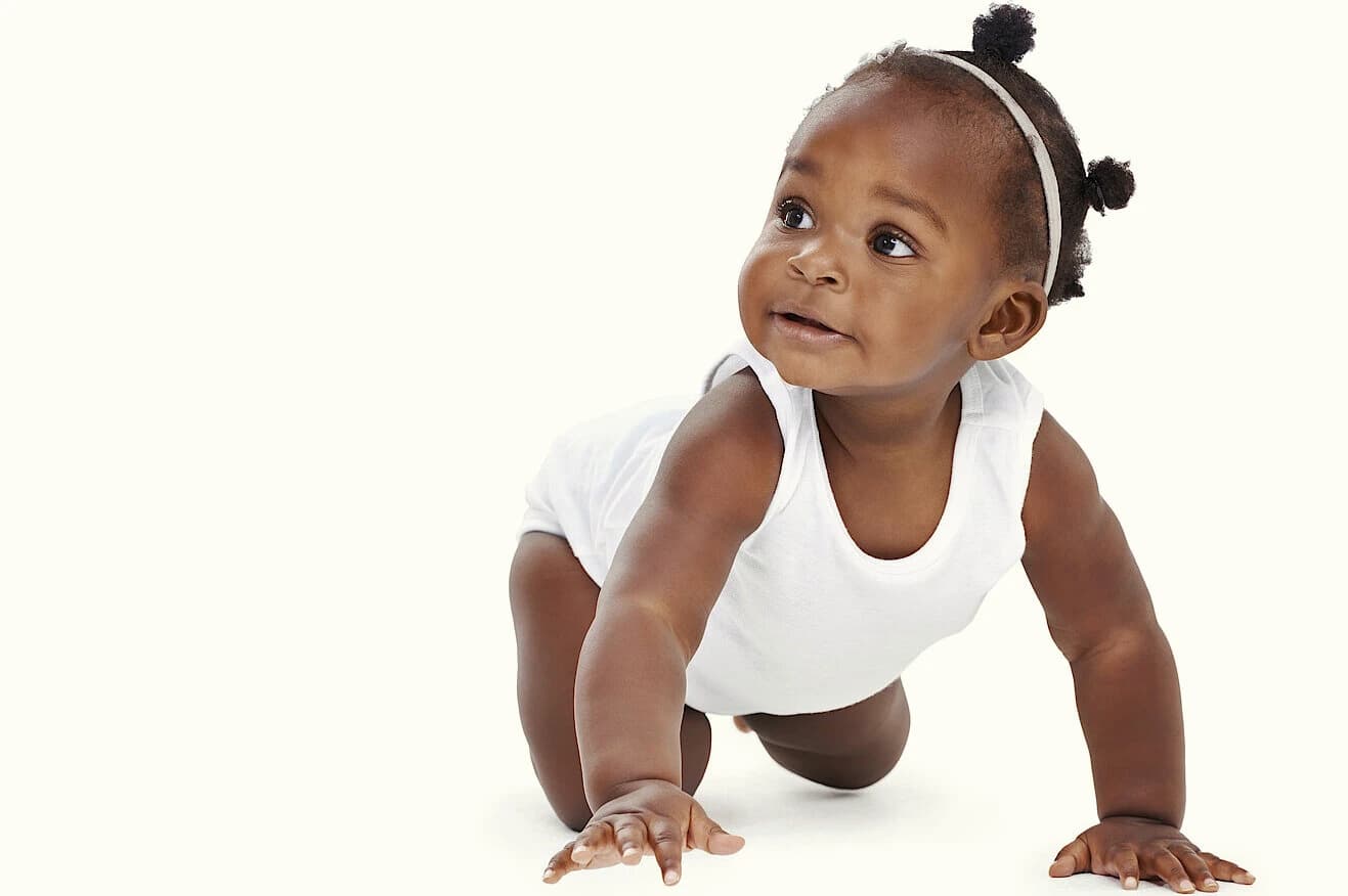 A baby crawling and looking up with curiosity