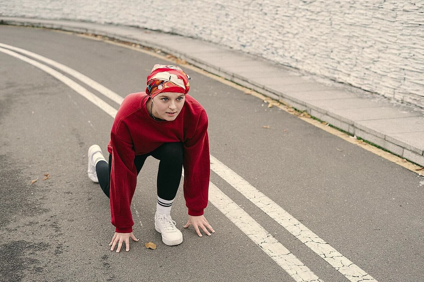 A young woman crouched at the start on a road
