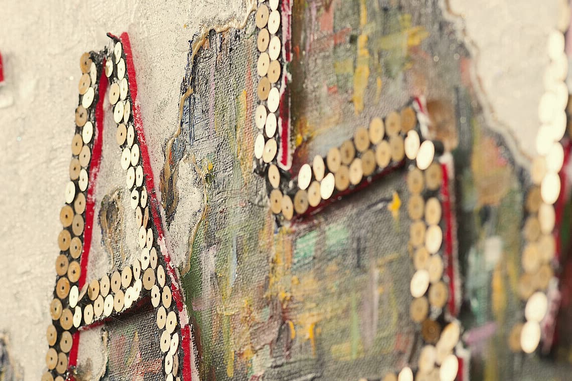 Letters of gold sequins on a painted canvas